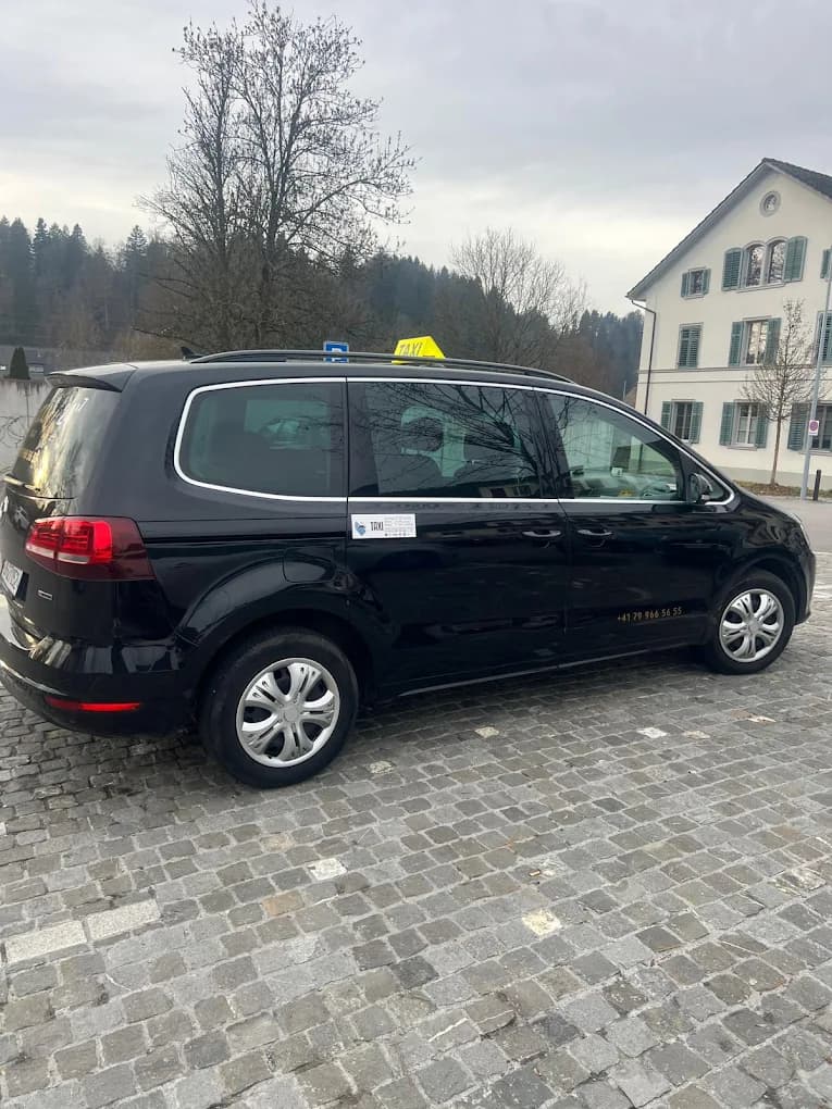 Schwarzer VW Sharan von Taxi Suli seitlich mit gelbem Taxischild